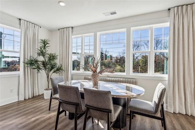 dining space with visible vents, baseboards, and wood finished floors