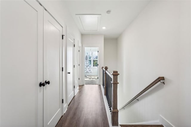 corridor featuring an upstairs landing, dark wood-type flooring, recessed lighting, baseboards, and attic access