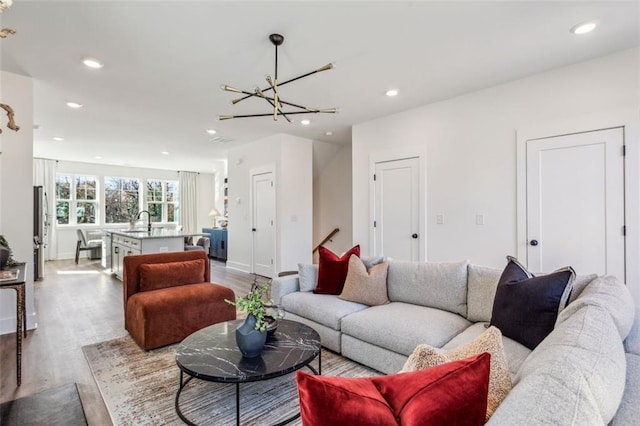 living room featuring a chandelier, recessed lighting, and wood finished floors