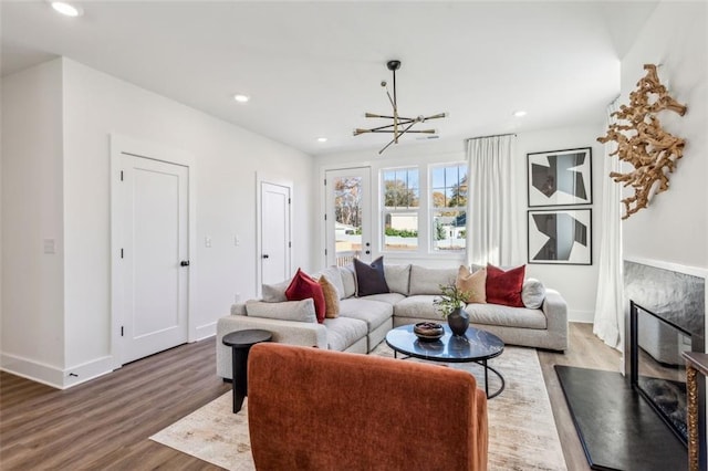 living room with a fireplace, recessed lighting, wood finished floors, and baseboards