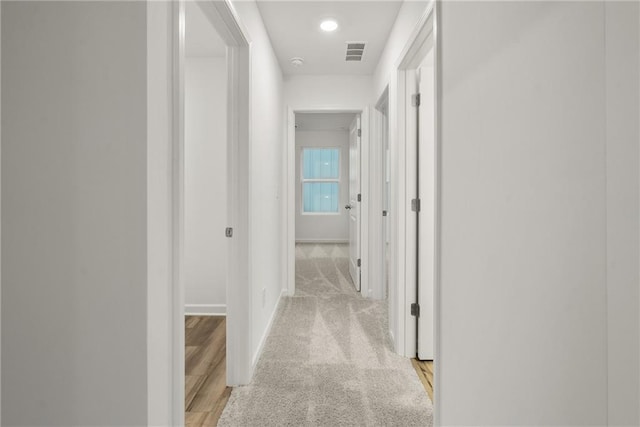 hallway with light colored carpet