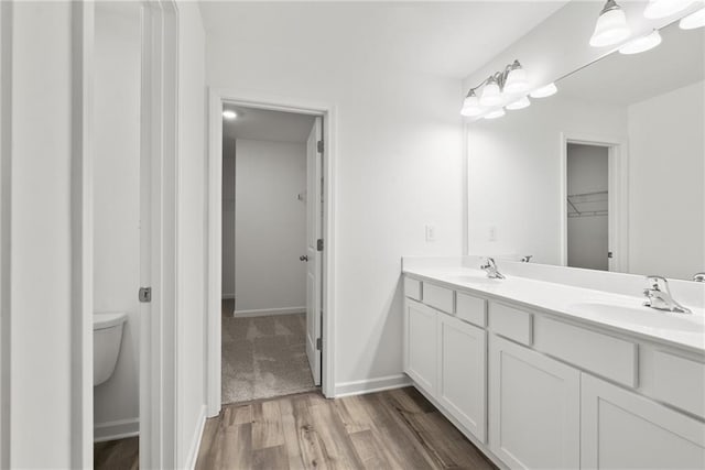 bathroom featuring vanity, toilet, and wood-type flooring