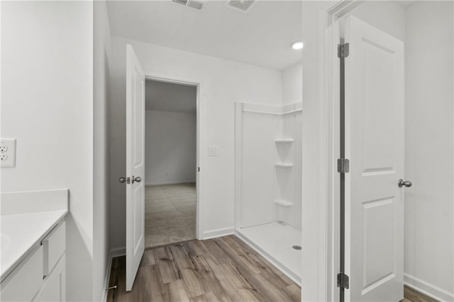 bathroom featuring vanity, hardwood / wood-style floors, and a shower