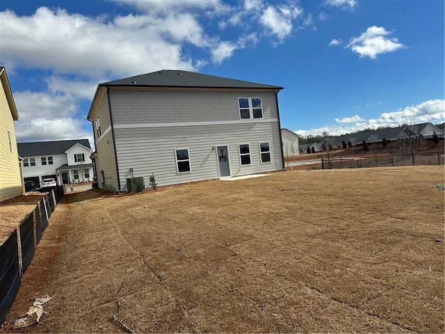 back of property featuring central AC unit and a lawn