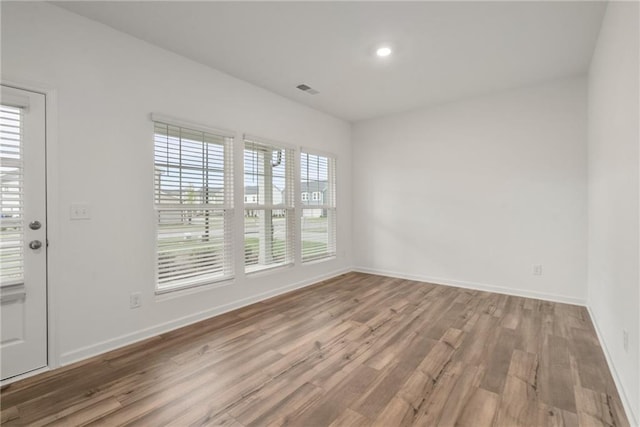 spare room with hardwood / wood-style floors and a healthy amount of sunlight