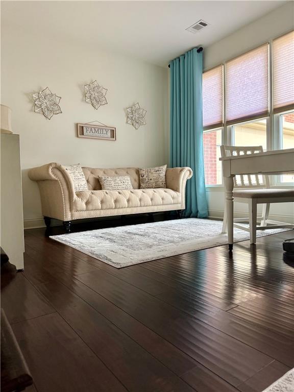 living area featuring visible vents and wood-type flooring