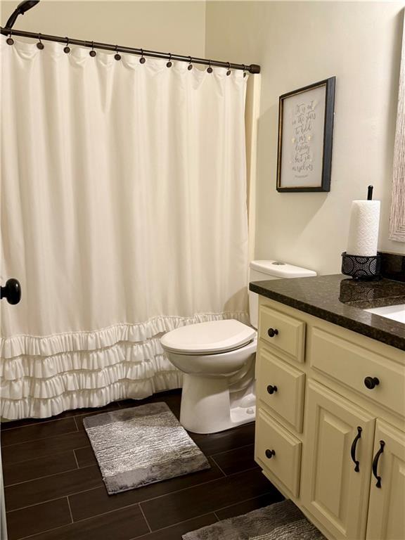 full bathroom with vanity, toilet, and wood tiled floor