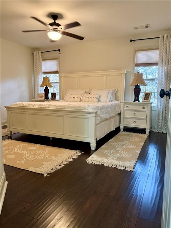 bedroom with visible vents, dark wood-type flooring, and ceiling fan