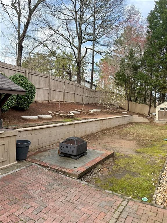 view of yard with a patio area, a storage unit, an outbuilding, and a fenced backyard