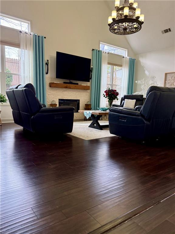 living room featuring a fireplace, wood finished floors, and a healthy amount of sunlight