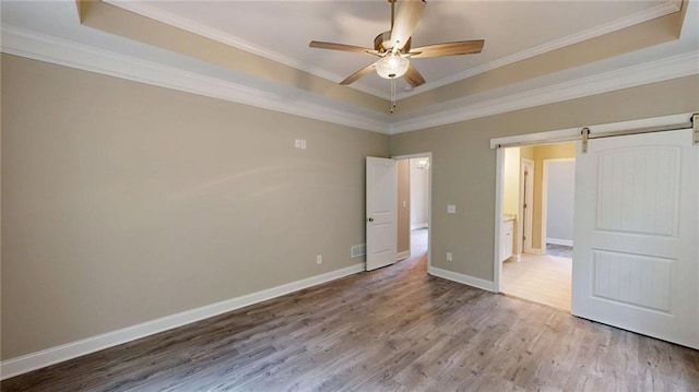 113 Cherokee Estates Dr, Cedartown, GA 30125 - unfurnished bedroom with a raised ceiling, wood finished floors, crown molding, and a barn door