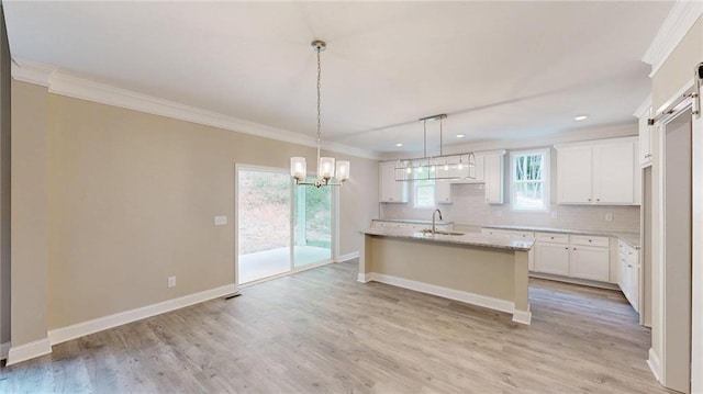 113 Cherokee Estates Dr, Cedartown, GA 30125 - kitchen with ornamental molding, backsplash, a chandelier, white cabinetry, and a barn door