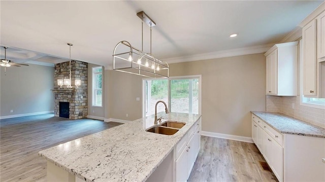 113 Cherokee Estates Dr, Cedartown, GA 30125 - kitchen with light wood-type flooring, white cabinets, decorative backsplash, a kitchen island with sink, and crown molding