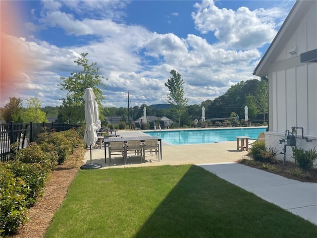 community pool with a yard, a patio, and fence
