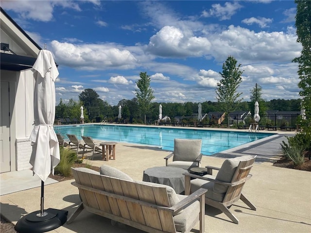 community pool featuring fence and a patio