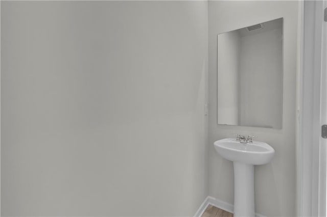 bathroom featuring visible vents, a sink, and baseboards