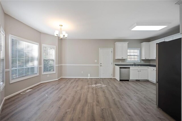 274 Sleepy Hollow Rd, Powder Springs, GA 30127 - kitchen featuring visible vents, baseboards, appliances with stainless steel finishes, light wood-style floors, and a notable chandelier