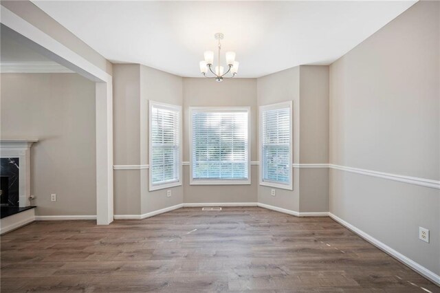 274 Sleepy Hollow Rd, Powder Springs, GA 30127 - unfurnished dining area featuring baseboards, a fireplace, wood finished floors, and an inviting chandelier