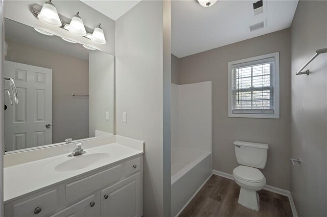 274 Sleepy Hollow Rd, Powder Springs, GA 30127 - bathroom with toilet, vanity, wood finished floors, baseboards, and visible vents