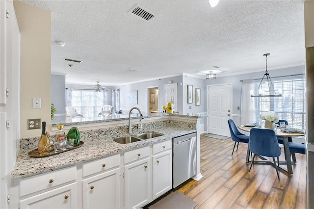 kitchen featuring white cabinetry, sink, hanging light fixtures, ornamental molding, and stainless steel dishwasher