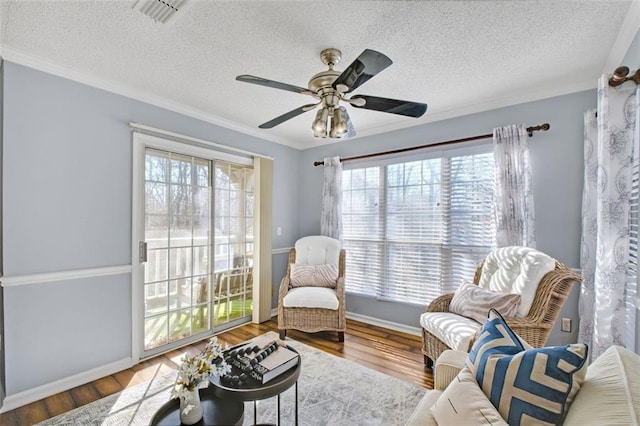 sitting room with hardwood / wood-style flooring, crown molding, plenty of natural light, and a textured ceiling