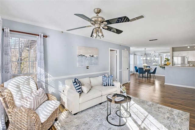 living room featuring ceiling fan, crown molding, and light wood-type flooring