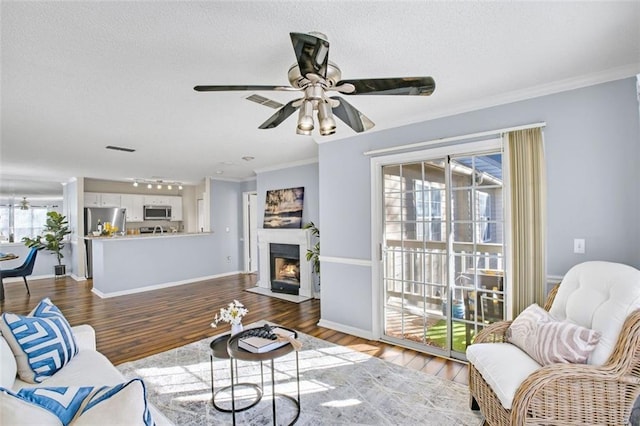 living room featuring hardwood / wood-style flooring, ornamental molding, and ceiling fan