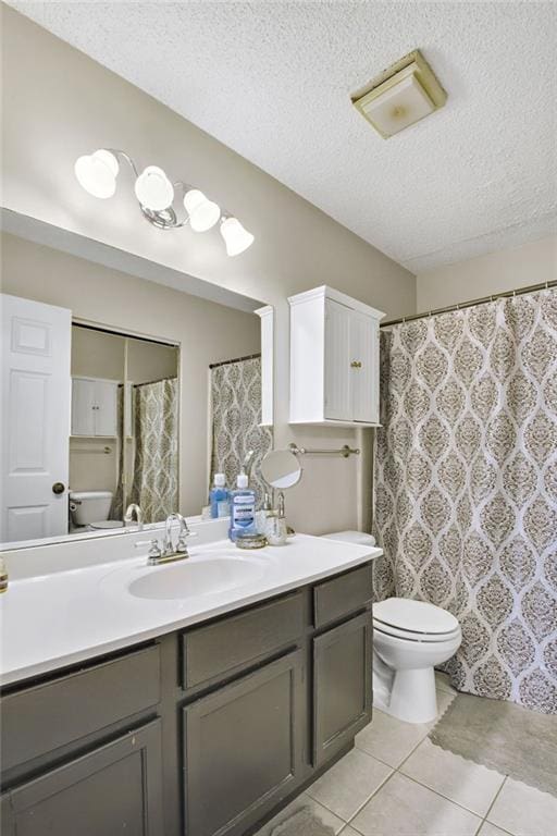 bathroom featuring toilet, a textured ceiling, tile patterned flooring, and vanity