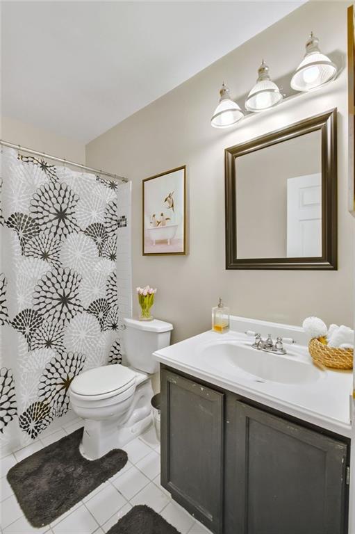 bathroom featuring toilet, tile patterned flooring, and vanity