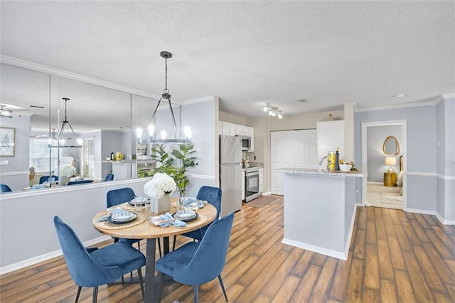 dining area with ornamental molding, hardwood / wood-style floors, and a textured ceiling