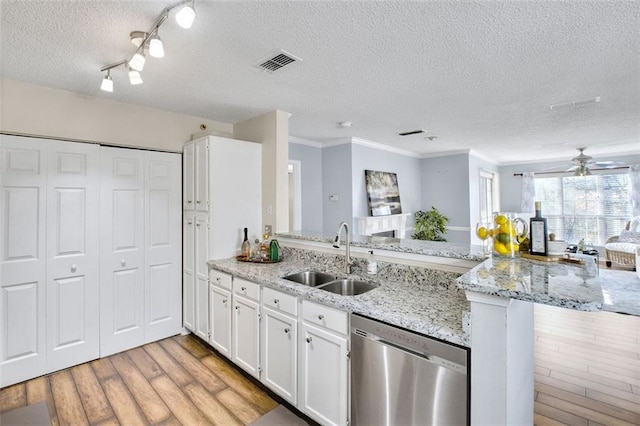 kitchen with a textured ceiling, white cabinets, dishwasher, sink, and kitchen peninsula