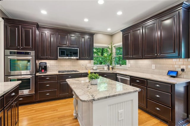 6795 Preston Glen Dr, Alpharetta, GA 30005 - kitchen featuring appliances with stainless steel finishes, light wood-type flooring, a sink, decorative backsplash, and crown molding
