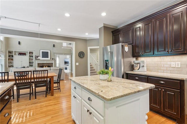 6795 Preston Glen Dr, Alpharetta, GA 30005 - kitchen featuring high end refrigerator, ornamental molding, backsplash, a warm lit fireplace, and dark brown cabinets