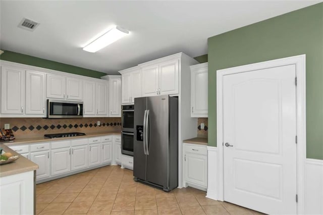 1027 Eagles Brooke Dr, Locust Grove, GA 30248 - kitchen with tasteful backsplash, visible vents, appliances with stainless steel finishes, and white cabinetry