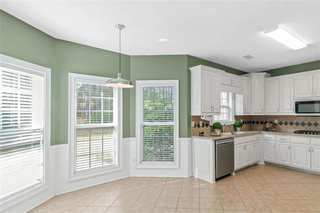 1027 Eagles Brooke Dr, Locust Grove, GA 30248 - kitchen with white cabinets, stainless steel appliances, and wainscoting