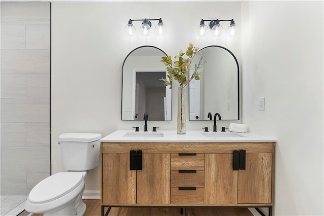 bathroom with toilet, wood-type flooring, and vanity