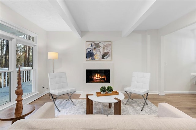 sitting room featuring beamed ceiling and hardwood / wood-style flooring