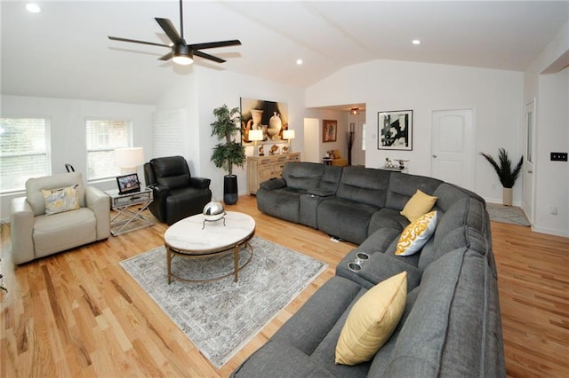 living room with ceiling fan, light wood-type flooring, and vaulted ceiling