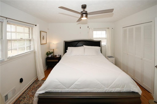 bedroom featuring hardwood / wood-style flooring, ceiling fan, and a closet