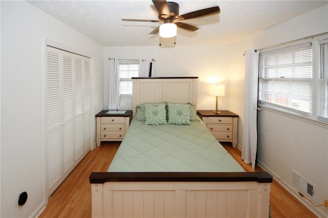 bedroom featuring ceiling fan, light hardwood / wood-style flooring, a closet, and radiator