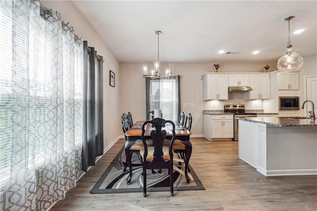 2646 Neighborhood Walk S, Villa Rica, GA 30180 - dining area with a chandelier, recessed lighting, baseboards, and light wood-style floors