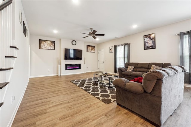 2646 Neighborhood Walk S, Villa Rica, GA 30180 - living room with light wood finished floors, baseboards, a ceiling fan, and a glass covered fireplace