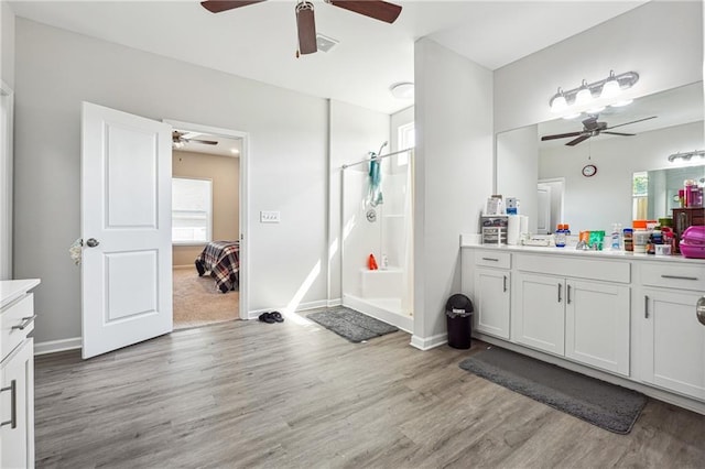 2646 Neighborhood Walk S, Villa Rica, GA 30180 - ensuite bathroom with a stall shower, ceiling fan, connected bathroom, vanity, and wood finished floors