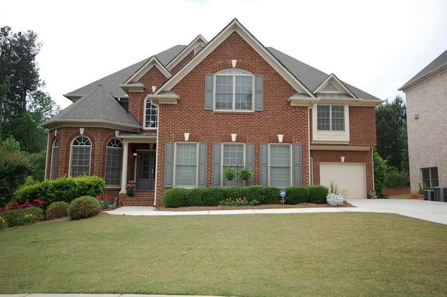 view of front of property featuring an attached garage, driveway, a front lawn, and brick siding