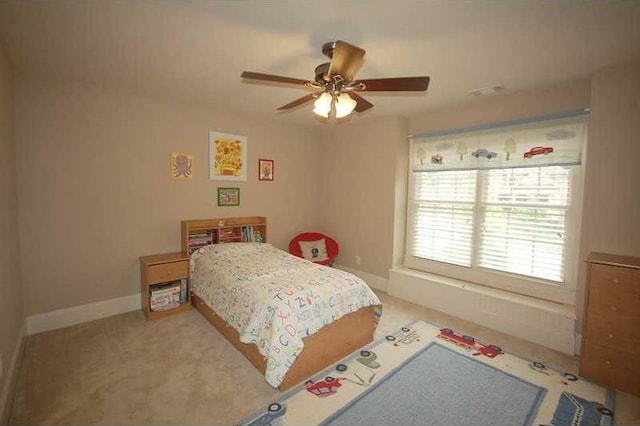 carpeted bedroom featuring baseboards and a ceiling fan