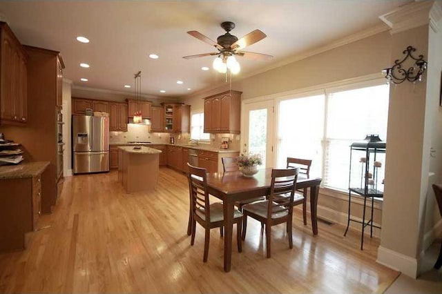 dining area featuring baseboards, recessed lighting, a ceiling fan, crown molding, and light wood finished floors