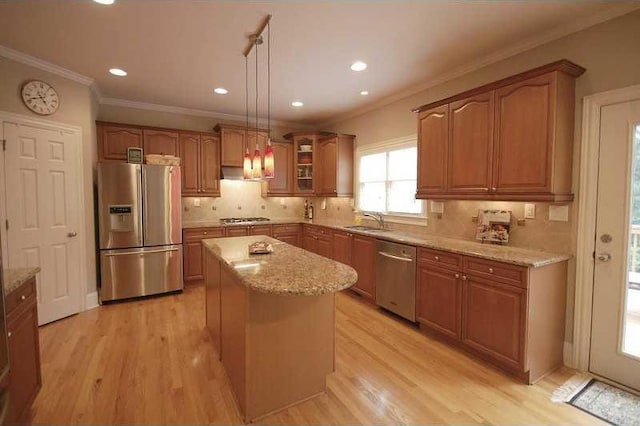 kitchen with light wood-style flooring, a sink, light stone countertops, and stainless steel appliances