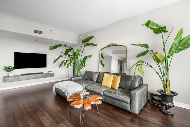 living area featuring dark wood finished floors, visible vents, and baseboards