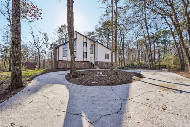 view of front of home featuring curved driveway and a chimney