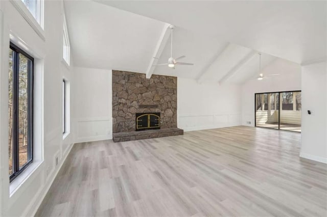 unfurnished living room featuring wood finished floors, beamed ceiling, a fireplace, and high vaulted ceiling